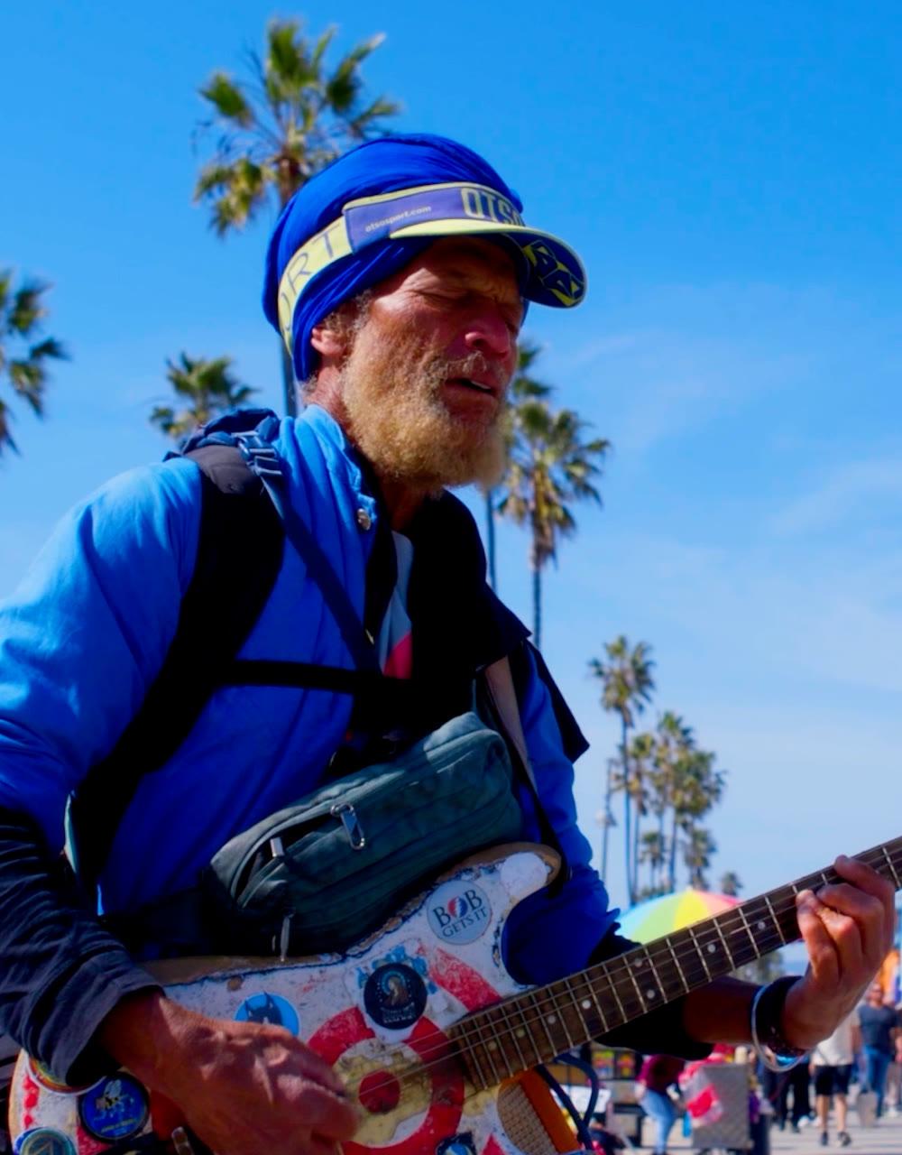 Venice Beach boardwalk with skaters and vendors